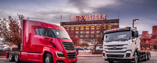 two budweiser e trucks displayed outdoors