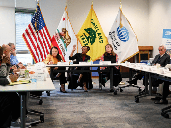 Image (Oakland City Council meeting with Port of Oakland, California Republic, and U.S. flags showing official government support for clean transportation initiatives)